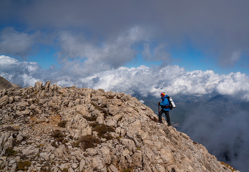 Mountaineer hiking on the edge of a rocky mountain path near Mount Tahtali, Antalya, Turkey