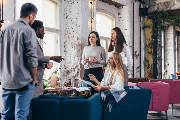 istock Group of people gathered around table during break in a coffee shop 1366491097