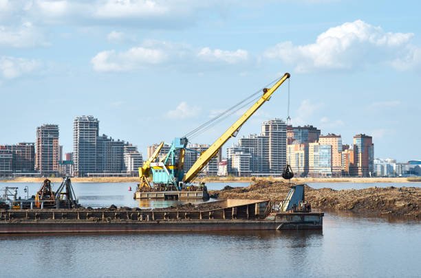 funktionierender baggerkran in küstennähe - industrial ship earth mover barge yellow stock-fotos und bilder