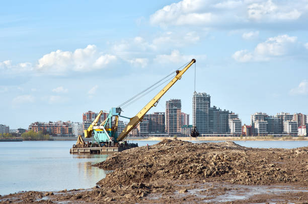 działający żuraw pogłębiający w pobliżu wybrzeża - industrial ship earth mover barge yellow zdjęcia i obrazy z banku zdjęć