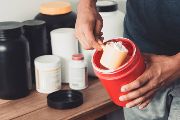 istock Hands holding scoop of creatine container with copy space healthy life. 1366492024