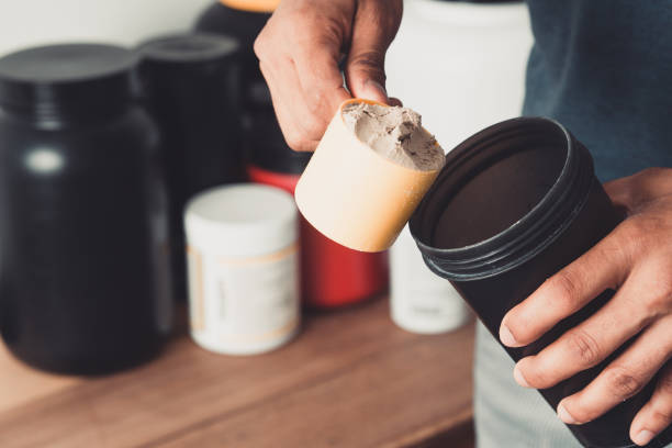 hände, die eine kugel molkenprotein und shaker mit kopierraum gesundes leben halten. - protein stock-fotos und bilder