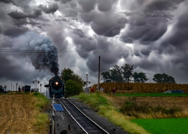 An Antique Restored Steam Freight Train Approaching Head on Blowing Smoke and Steam With People Watching
