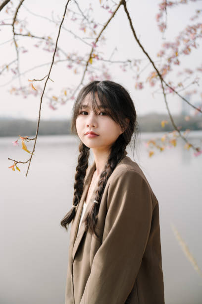 istock Asian women under cherry blossoms 1366495052
