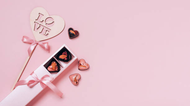 istock Festive composition for Valentine's Day. Chocolate candy hearts satin summer on a pink background. Flat 1366498719