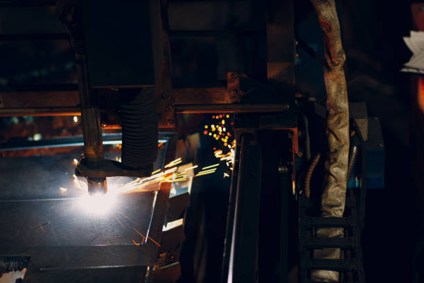istock Automatic cnc laser cutting machine working with sheet metal with sparks. Metalworking industrial manufacturing factory 1366500499