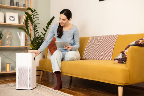 istock Mature woman turning on air purifier using a digital tablet 1366500800