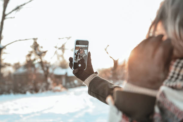istock Young woman taking selfie outdoors in winter 1366504892