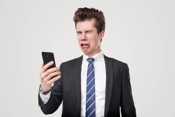 istock Sad funny businessman crying and using smartphone 1366505320