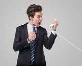 Irritated salesman shouting into telephone receiver