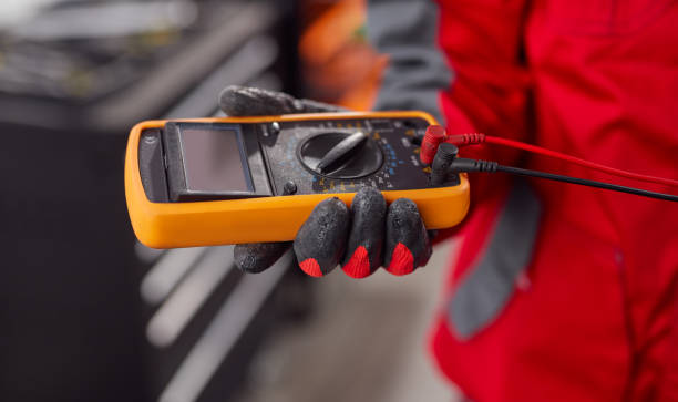 Male mechanic checking voltage of battery Soft focus of crop male technician using multimeter to measure voltage of car battery while working in garage electrician multimeter stock pictures, royalty-free photos & images