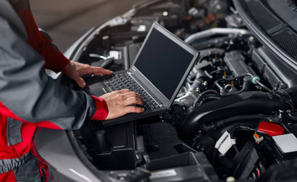 istock Crop mechanic conducting car diagnostics in workshop 1366505401