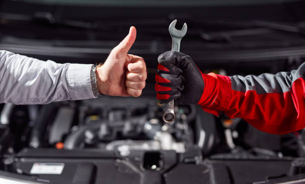 A person inspects a car's engine with the hood open, displaying concern and problem-solving. This image embodies concepts such as mechanical troubleshooting, car maintenance, and determination to resolve vehicle issues.