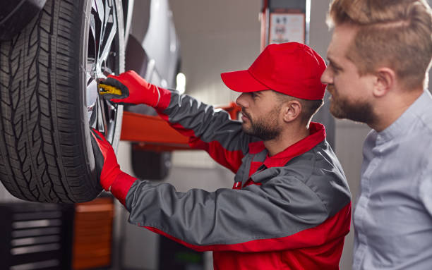 Mechanic with customer checking car wheel stock photo
