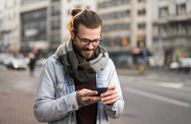 istock Young man using phone in the city. 1366509450