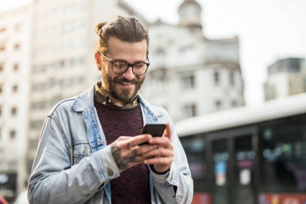 istock Young man using phone in the city. 1366509910