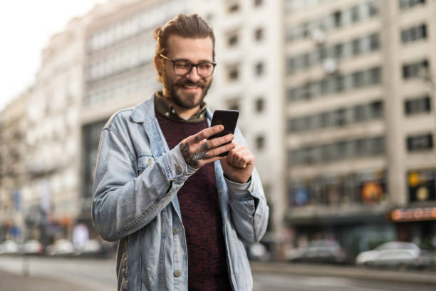 istock Young man using phone in the city. 1366509924
