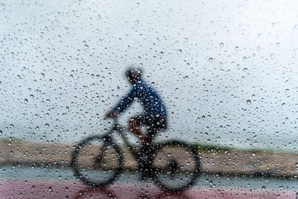 istock A person riding a bicycle in the rain. 1366511231