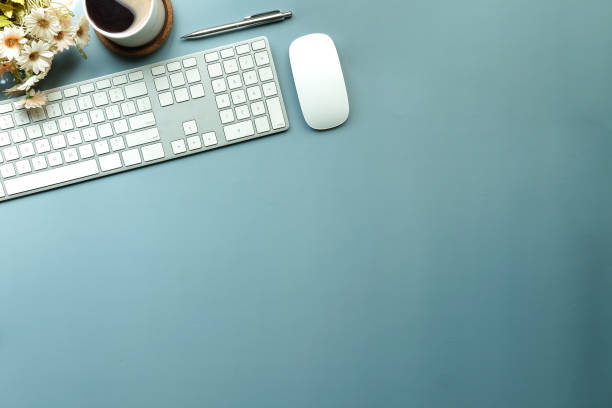 istock Top view, wireless keyboard, mouse and coffee cup on blue background with copy space. 1366512897