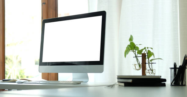 istock Creative workplace with modern computer, houseplant and books on white table. Blank screen for your advertising text. 1366513550
