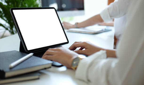 istock Close up view young businesswoman working with computer tablet on white office desk. 1366513627