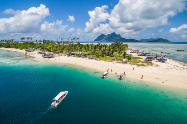 Aerial view of Maiga island panorama, beautiful blue lagoon and coral reef. Aerial view of Maiga island panorama, beautiful blue lagoon and coral reef. island of borneo stock pictures, royalty-free photos & images