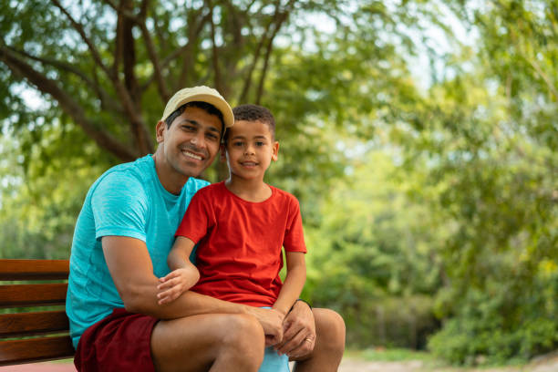 istock Father and son sitting on a park bench 1366517674