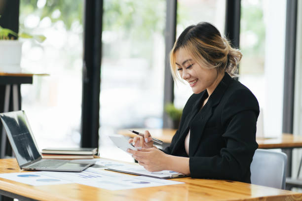 istock Young Asian woman entrepreneur/ Business owner using a smartphone and working with computer at home 1366522491