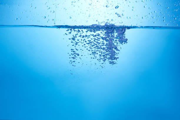 istock Blue background with water bottle falling in and multiplle drops and splashed. Water bubbles texture 1366522646