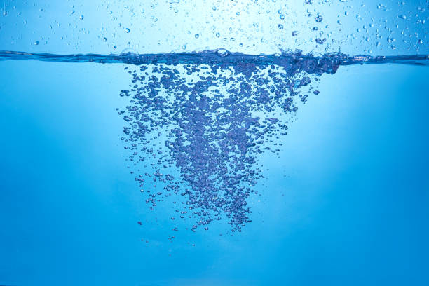 istock Blue background with water bottle falling in and multiplle drops and splashed. Water bubbles texture 1366522725