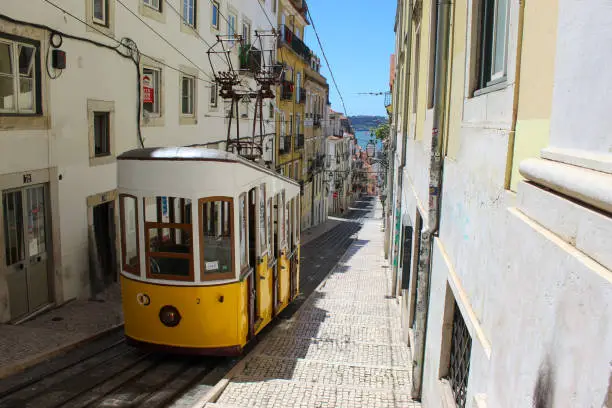 Photo of Vintage tram in the city center of Lisbon in a beautiful summer day, Portugal. Traditional yellow tram on a street in Lisbon, Portugal.