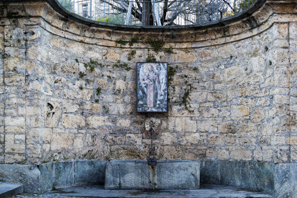 The ancient holy fountain at the side of the Cathedral of Saint Lawrence, Lugano Lugano, Switzerland - January 14, 2022: The ancient holy fountain at the side of the famous Cathedral of Saint Lawrence (Built in 818) in Lugano on the road of via borghetto. jusus stock pictures, royalty-free photos & images