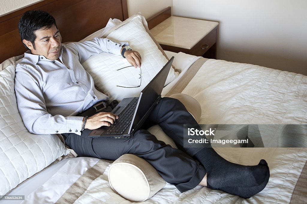 Uomo d'affari che lavora in camera d'albergo - Foto stock royalty-free di Adulto
