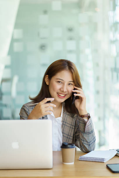 istock Laughing female entrepreneur talking with a client on her cellphone 1366529572