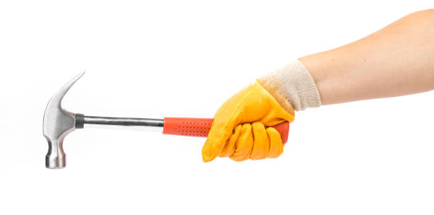 istock Man's hand in glove holds hammer. 1366531730