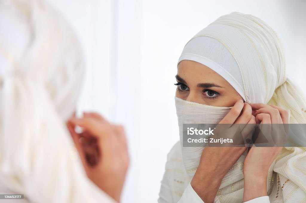 Красивые мусульманских женщина, глядя на зеркало и делая ее Шарф - Стоковые фото Арабеска роялти-фри