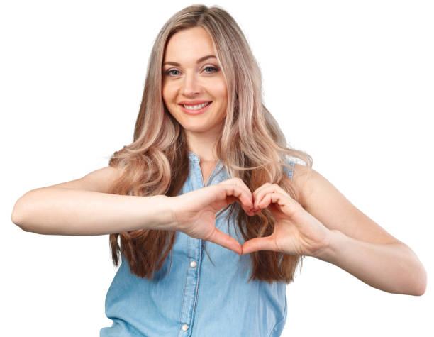 istock Young woman showing hand heart gesture isolated on white 1366534455
