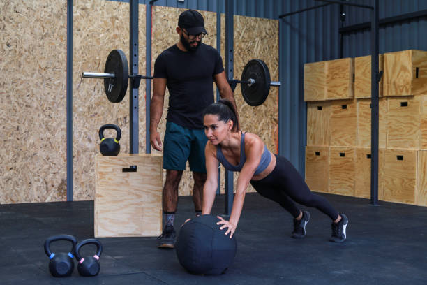istock Trainer helping woman to do abs training 1366534657