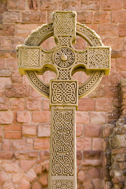 Holy Island Celtic Cross Celtic Cross outside the monastery at Holy Island in Northumberland lindisfarne monastery stock pictures, royalty-free photos & images