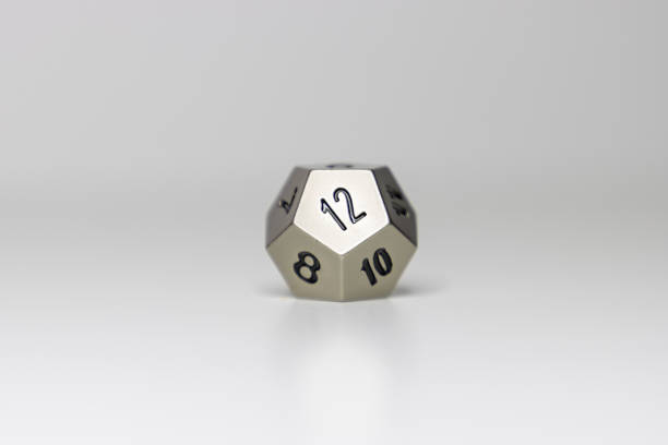 12-sided dice centered against white background stock photo
