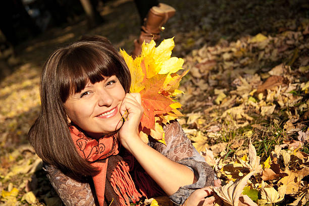 istock woman with autumn leaves 136653548