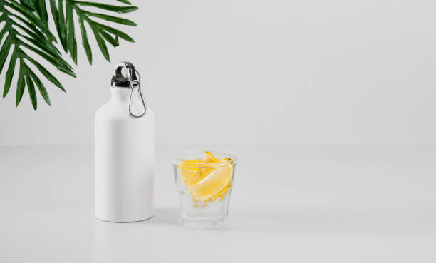 Health care, healthy food and drink concept. Fresh cool lemon water in a bottle and in a glass. Fitness shake, detox drink or lemonade. Selective focus with copy space stock photo