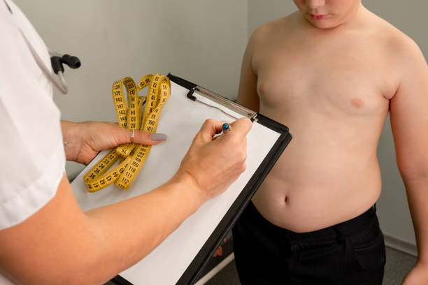 fettleibigkeitsproblem bei kindern und gewichtsverlust. arzt untersucht dicken jungen - child obesity stock-fotos und bilder