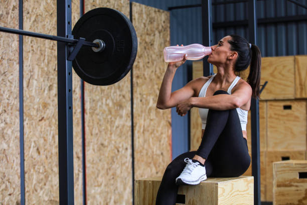 istock Woman drinking water after gym workout 1366536255