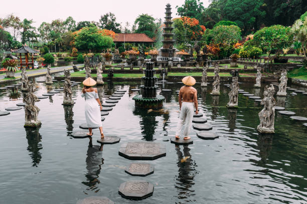A beautiful couple is traveling on the island of Bali in Indonesia. A couple walks through a water temple in Indonesia. Travel to Asia. The tourists travel. Fountain on the island of Bali in Indonesia stock photo