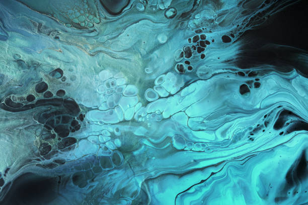 istock Fluid Art. Fluorescent blue waves with golden particles on black background. Marble effect background or texture 1366537323