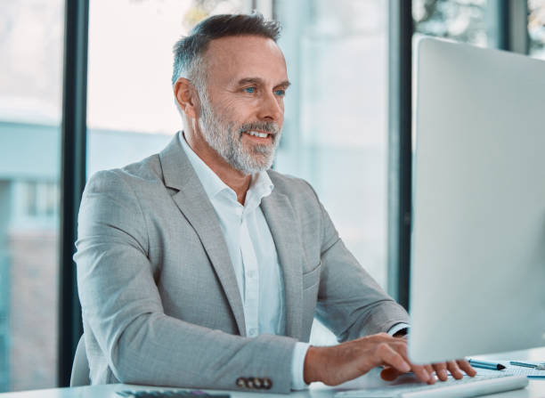 istock Shot of a mature man using a computer at work in a office 1366538068