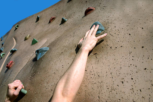 Person climbing on rock climbing wall stock photo