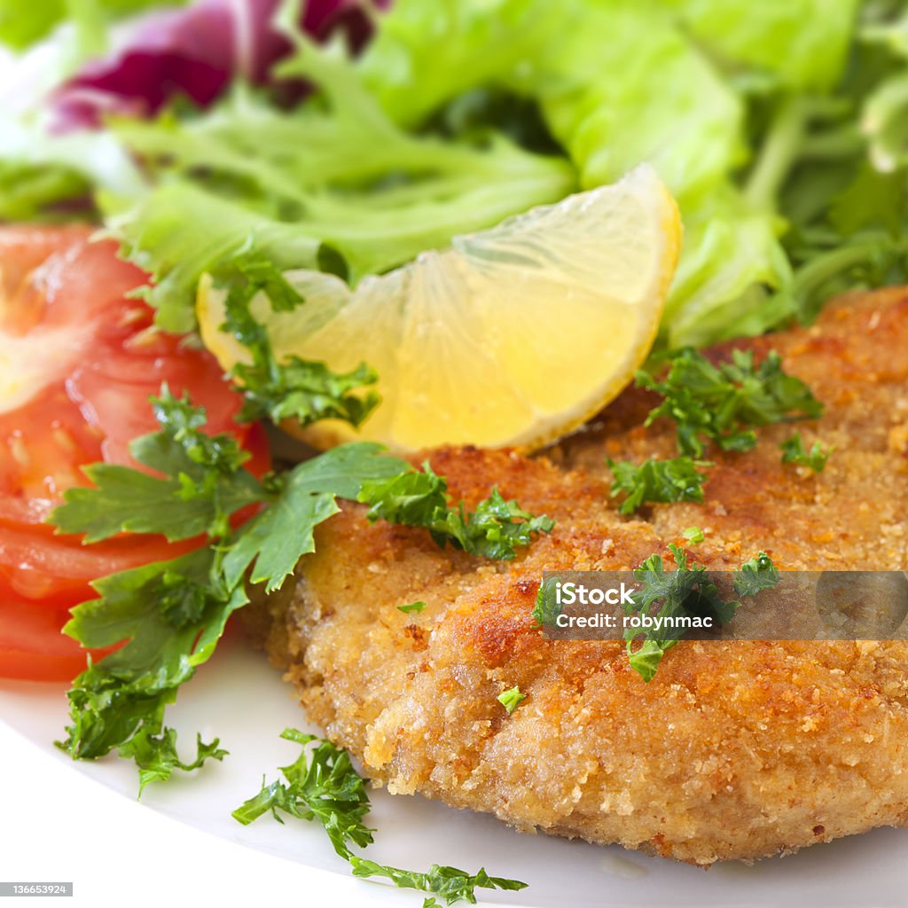 Schnitzel with Salad Schnitzel with salad, garnished with lemon and parsley. Breaded Stock Photo