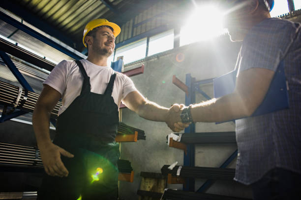 istock Smiling metal worker greeting manager in aluminum mill. 1366545209